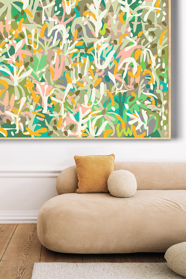 Abstract art painting with colorful patterns on a wall above a beige sofa.